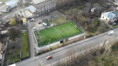 Suni çim ve eskrim ile şehrin ortasında Futbol sahası. Çocuklar futbol oynar