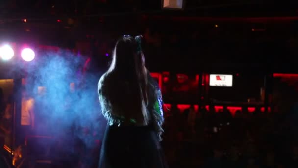 Meisje dat zingt en dansen op het podium, Achteraanzicht van zanger. Licht en rook op het podium. — Stockvideo