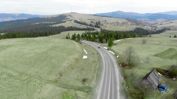 Giro aéreo disparó dos coches que se mueven en la carretera uno por uno en las montañas — Vídeos de Stock