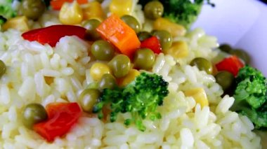 Sebze dilimleri ile Pirinç yakın çekim, yeşillik ve kırmızı biber beyaz bir tabak iplik üzerinde