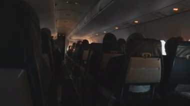 Yolcu uçağı ekonomi sınıfı. Kabinde oturan yolcular. Uçuşta hafif bir titreşim