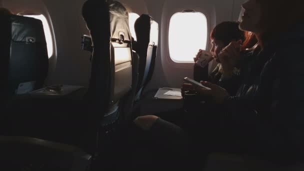 Polônia. Varsóvia. 20 de abril de 2019. Avião de passageiros avião classe economia LOT. Na cabine, passageiros sentados. Uma ligeira vibração em voo — Vídeo de Stock
