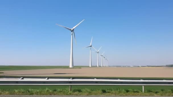 Flevoland Hollanda 'daki Ijsselmeer gölündeki yel değirmeni parkı. Araba penceresinden hızla görüntüle. — Stok video