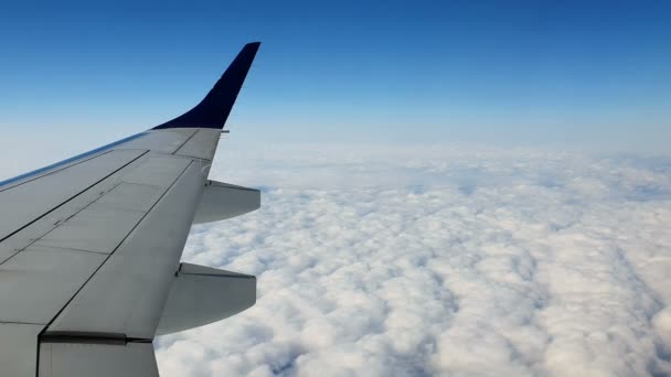 Vue par la fenêtre de l'avion. L'aile de l'avion contre le ciel bleu et les nuages blancs. Contexte 