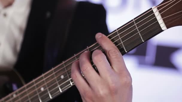 Крупный план пальцев, которые меняют аккорды на акустической гитаре — стоковое видео