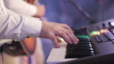 konser sırasında elektronik synthesizer üzerinde oynayan müzisyenin parmakları