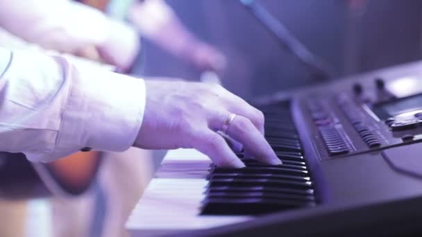 Vingers van de muzikant die tijdens het concert op de elektronische synthesizer speelt — Stockvideo