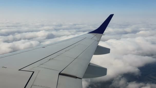 Vue par la fenêtre de l'avion. L'aile de l'avion contre le ciel bleu et les nuages blancs. Contexte 