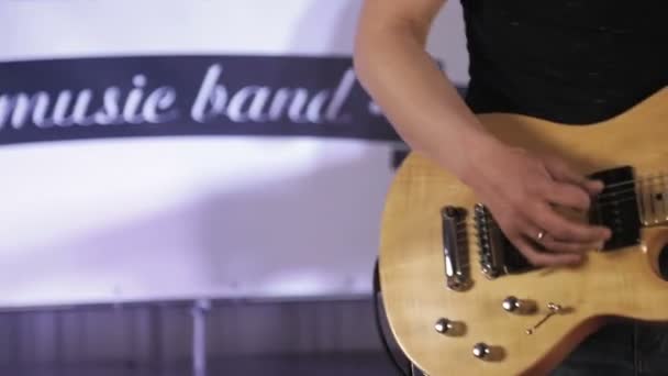 Rock müzisyeni sarı elektro gitar çalar, renkli ışık ile sahnede — Stok video