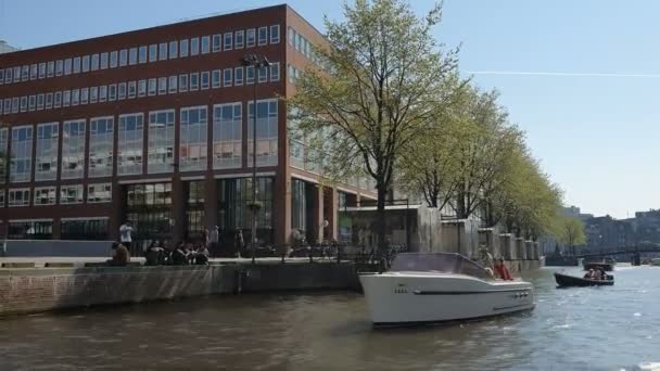 オランダ、アムステルダム25.04.2019. アムステルダムの運河に駐車古い船.ツアーボートからの眺め。広角レンズで撮影 — ストック動画