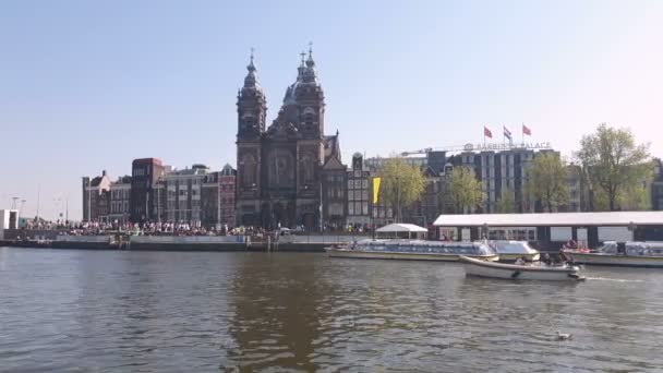 Amesterdão, Países Baixos. 25.04.2019. A Basílica de São Nicolau, em Amsterdã, foi filmada a partir das águas de um canal. Amesterdão Países Baixos. Empurre em tiro . — Vídeo de Stock