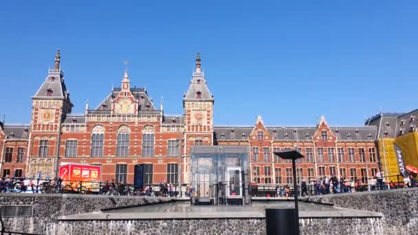 Amsterdam, Paesi Bassi. 25.04.2019. Stazione centrale di Amsterdam. Turisti a piedi vicino alla stazione centrale e l'ingresso sotterraneo alla stazione della metropolitana — Video Stock