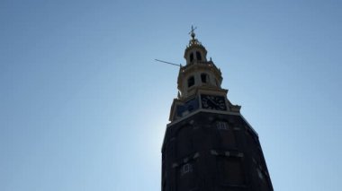 Saat kulesi Montelbaanstoren tur teknesi kaldırıldı. Montelbaanstoren Kulesi mavi gökyüzü arka plan, kuleden çıkış şansı ve kamera içine parlar