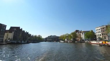 Tur teknesinden Amsterdam kanal turu görünümü. Güneşli havalarda şehrin eski bölümünün inanılmaz manzarası.
