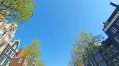 Tur teknesinden Amsterdam kanal turu görünümü. Güneşli havalarda şehrin eski bölümünün inanılmaz manzarası.