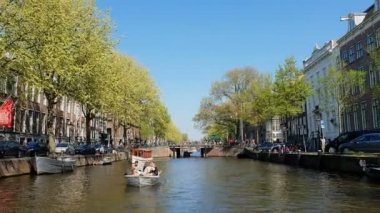 Tur teknesinden Amsterdam kanal turu görünümü. Güneşli havalarda şehrin eski bölümünün inanılmaz manzarası.