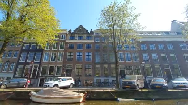 荷兰阿姆斯特丹。25.04.2019. 阿姆斯特丹房屋的宏伟建筑。房子向不同方向倾斜。阳光明媚的一天，阿姆斯特丹房屋的外墙 — 图库视频影像