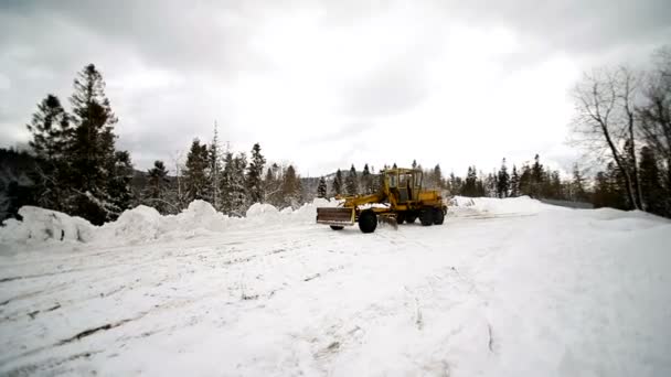 Ein Traktor räumt den Schnee vom Land, damit das Auto den Schnee von der großen Markierungstechnik reinigt — Stockvideo