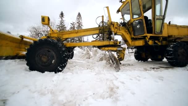 Ein Traktor räumt den Schnee vom Land, damit das Auto den Schnee von der großen Markierungstechnik reinigt — Stockvideo