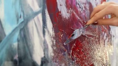 Spatula ve akrilik boyalar ile çizim kapatın. Bir kadın sanatçının eli, çizim için bir spatula tutan ve tuvalboya uygulamak