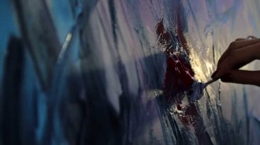 Sanatçının yakın çekim sıcak ışık akrilik siyah ve koyu renkler çizer. Spatula ve akrilik boyalar ile çizim.