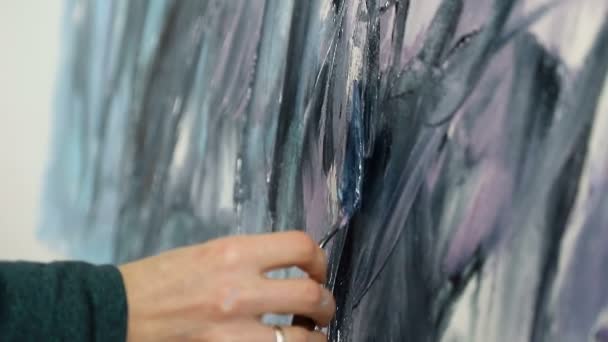 Blízko umělce se na teplém světle vyčerpá Akrylová černá a tmavá barva. Kreslení stěrkou a akrylovými barvami. — Stock video