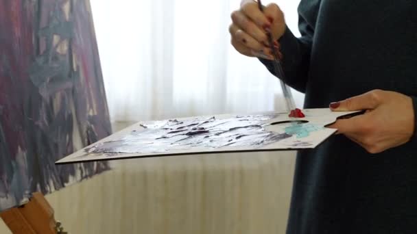 Καλλιτέχνης μείγματα διαφόρων χρωμάτων ακρυλική μπογιά με ένα πινέλο για το σχέδιο. Προετοιμασία των χρωμάτων για την κατάρτιση εικόνες — Αρχείο Βίντεο