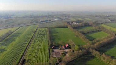 Hollanda'da havadan küçük güzel köy manzarası. Hollanda'da küçük bir köyün evlerinin ve sokaklarının çatıları üzerinde uçmak.