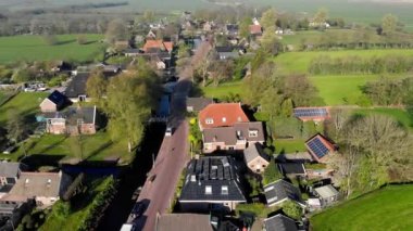 Hollanda'da havadan küçük güzel köy manzarası. Hollanda'da küçük bir köyün evlerinin ve sokaklarının çatıları üzerinde uçmak.