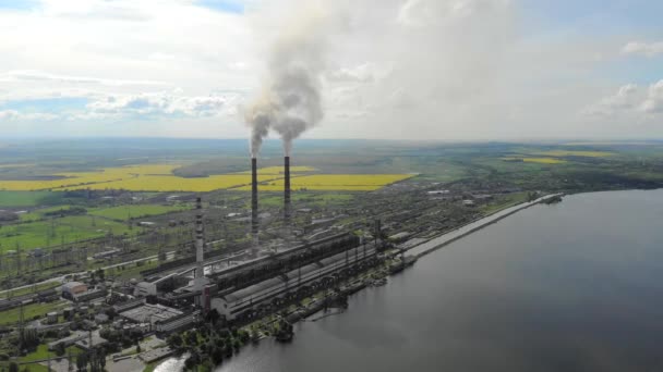 Vue aérienne Pipe téléplastique qui émettent de la fumée noire, sur fond de belle nature, de champs verts et d'un grand lac . — Video