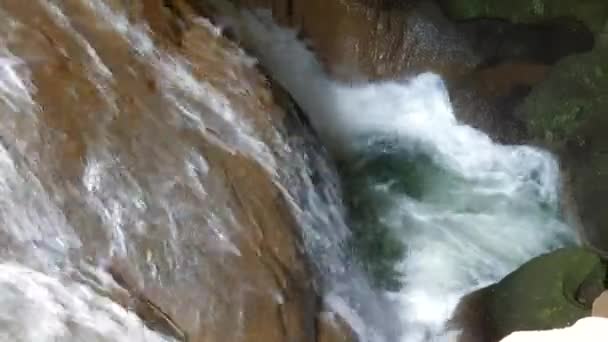 Strong water flow in the cave. A small waterfall underground. The flow of water breaks between the stones — Stock Video