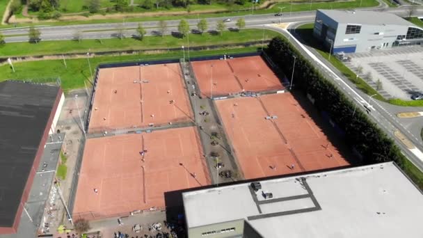 Vista aérea quadras de tênis e atletas que realizam um jogo de tênis. Quadras de tênis com pessoas que jogam tênis . — Vídeo de Stock