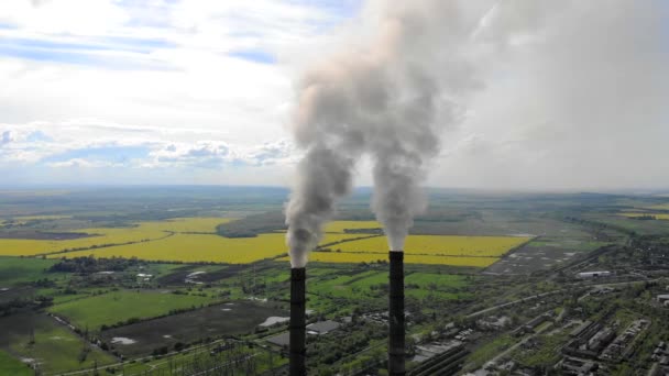 Widok z lotu ptaka gęsty gruby dym pochodzi z rur przemysłowych przed błękitnym niebem i naturą — Wideo stockowe