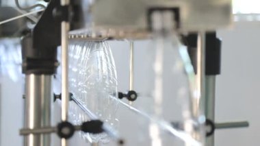 Plastik şişede maden suyunuşişeleme için şişelerin Otomatik konveyör hattına elle beslenmesi. Şişelere saf kaynak suyu şişeleyen su fabrikası. Seçici odaklama.