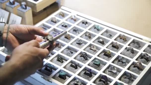 Jeweler using a measuring stick, measures the size of the rings of precious stones. — Stock Video