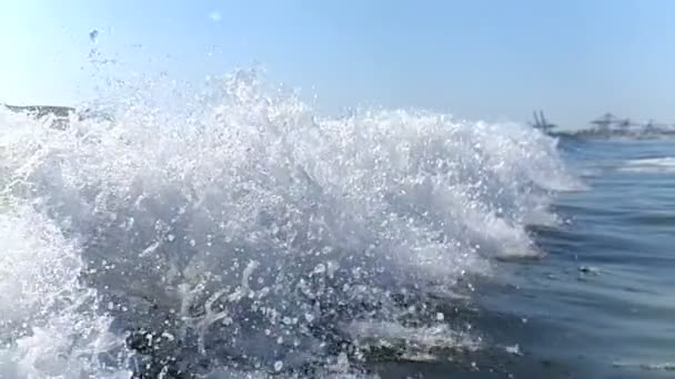 Grote bries golven close-up in slow motion, verplaatsen naar de kust. De spray van de Golf glinstert in de zon en giet langzaam, raakt elkaar aan en valt op het water. — Stockvideo