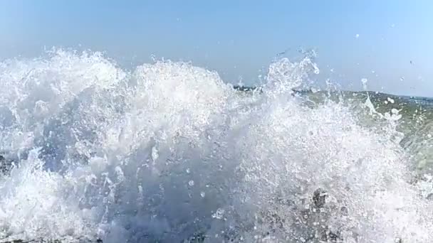 大风在慢动作中近距离地吹来，向岸边移动。海浪的喷雾在阳光下闪闪发光，慢慢地倾泻，相互撞击，落在水面上. — 图库视频影像