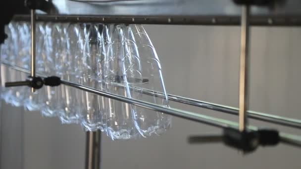 Manuelle Zuführung von Flaschen in die automatische Förderlinie zur Abfüllung von Mineralwasser in die Kunststoffflasche. Wasserfabrik-Abfüllung reinen Quellwassers in Flaschen. Selektiver Fokus. — Stockvideo