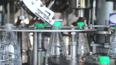 su şişeleme hattı. Plastik kapakların otomatik beslemesi ve kapanması