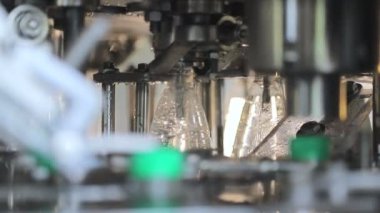 su şişeleme hattı. Plastik kapakların otomatik beslemesi ve kapanması