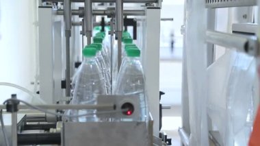 Sıcaklık presi film ile plastik şişe otomatik ambalaj. Daha fazla taşıma için şişelerin ambalajlama.