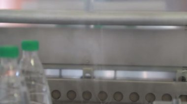 Sıcaklık presi film ile plastik şişe otomatik ambalaj. Daha fazla taşıma için şişelerin ambalajlama.
