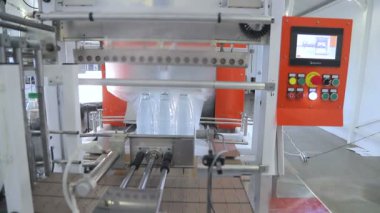 Sıcaklık presi film ile plastik şişe otomatik ambalaj. Daha fazla taşıma için şişelerin ambalajlama.