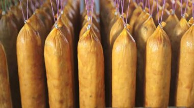 Sosisseri üretimi. Sosisler üst üste ipliklere asılı..