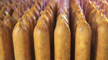 Sosisseri üretimi. Sosisler üst üste ipliklere asılı..