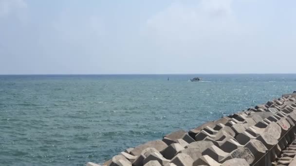 Boot, das auf dem Meer segelt und von einem steinernen Pier aus schießt. Bootsfahrt auf dem Meer an einem sonnigen Tag — Stockvideo