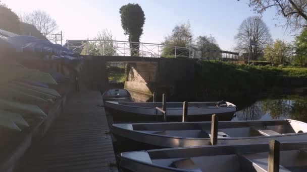 小さな村の小さなボートステーション。桟橋に立つ小さなボート。オランダの運河を移動するボート — ストック動画