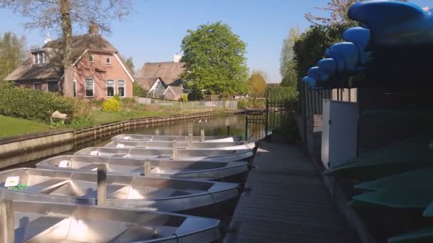 小さな村の小さなボートステーション。桟橋に立つ小さなボート。オランダの運河を移動するボート — ストック動画