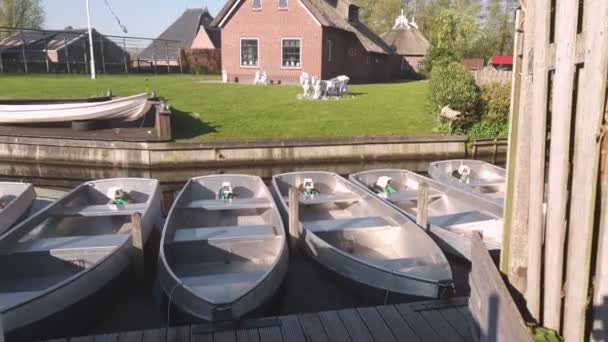Mała stacja łodzi w małej wiosce. Małe łodzie, stojąc na molo. Łodzie do poruszania się po kanałach Holandii — Wideo stockowe