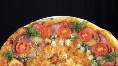 Lezzetli taze pişmiş İtalyan pizza, yakın çekim, dönen bir platform üzerinde dönüyor